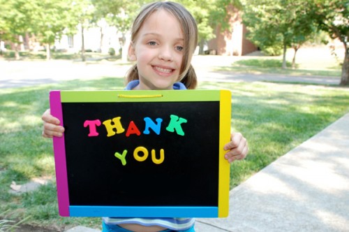 child holding thank you sign